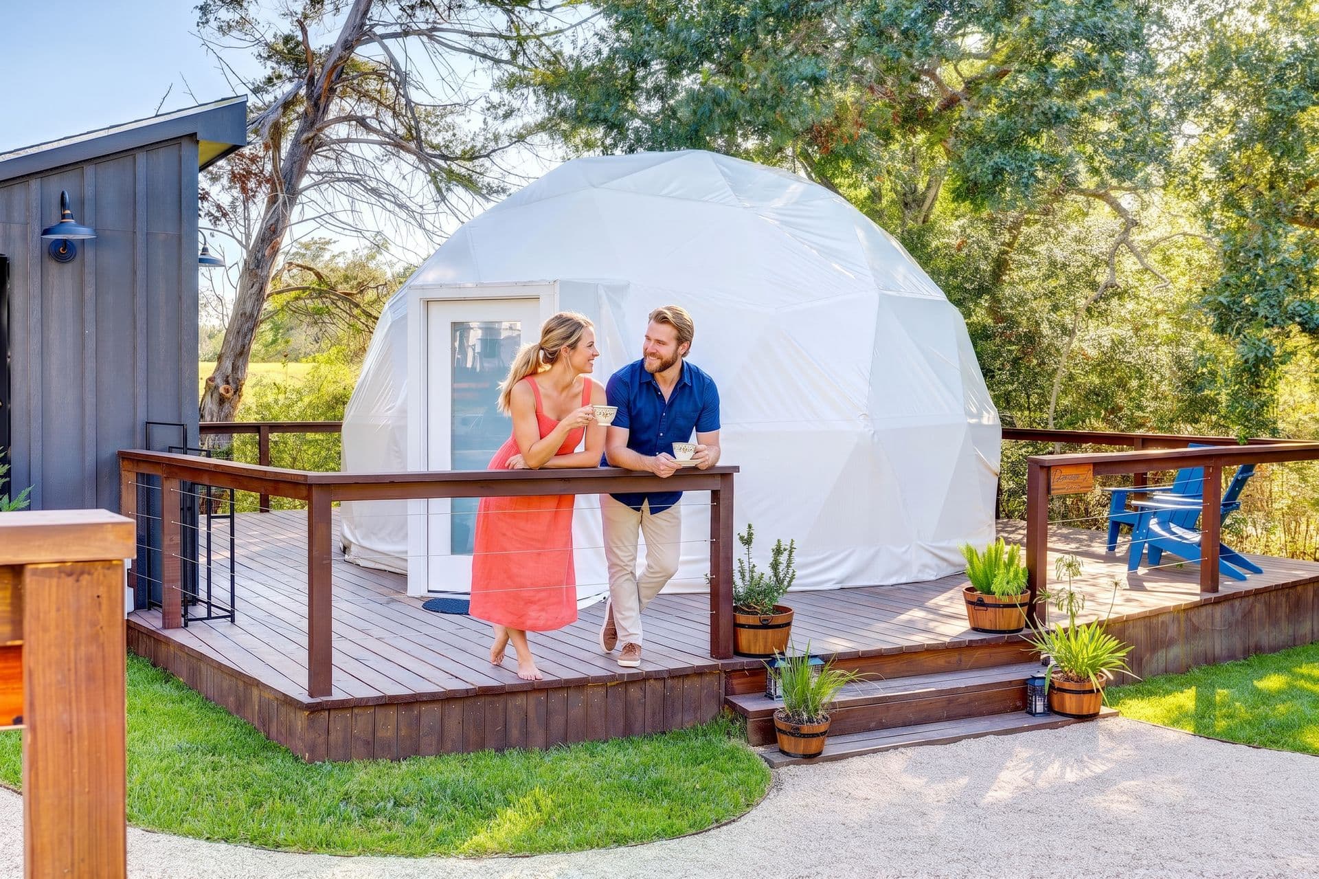 A couple on the deck of a geodesic dome stay