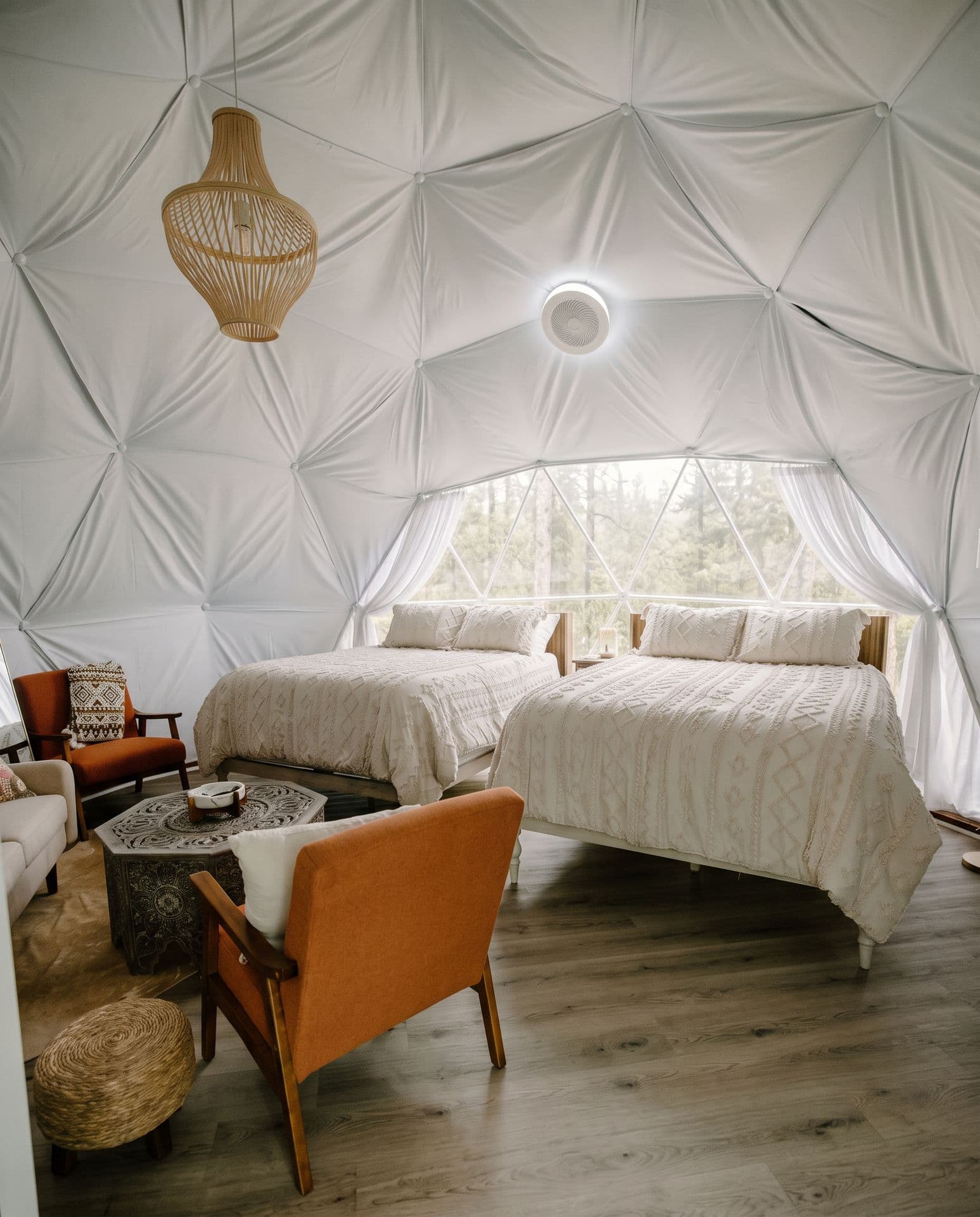Inside a dome: two beds, rattan lamp, mid-century chairs