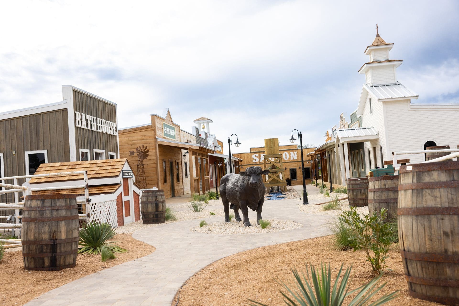The western village main street, wooden storefronts and a buffalo statue