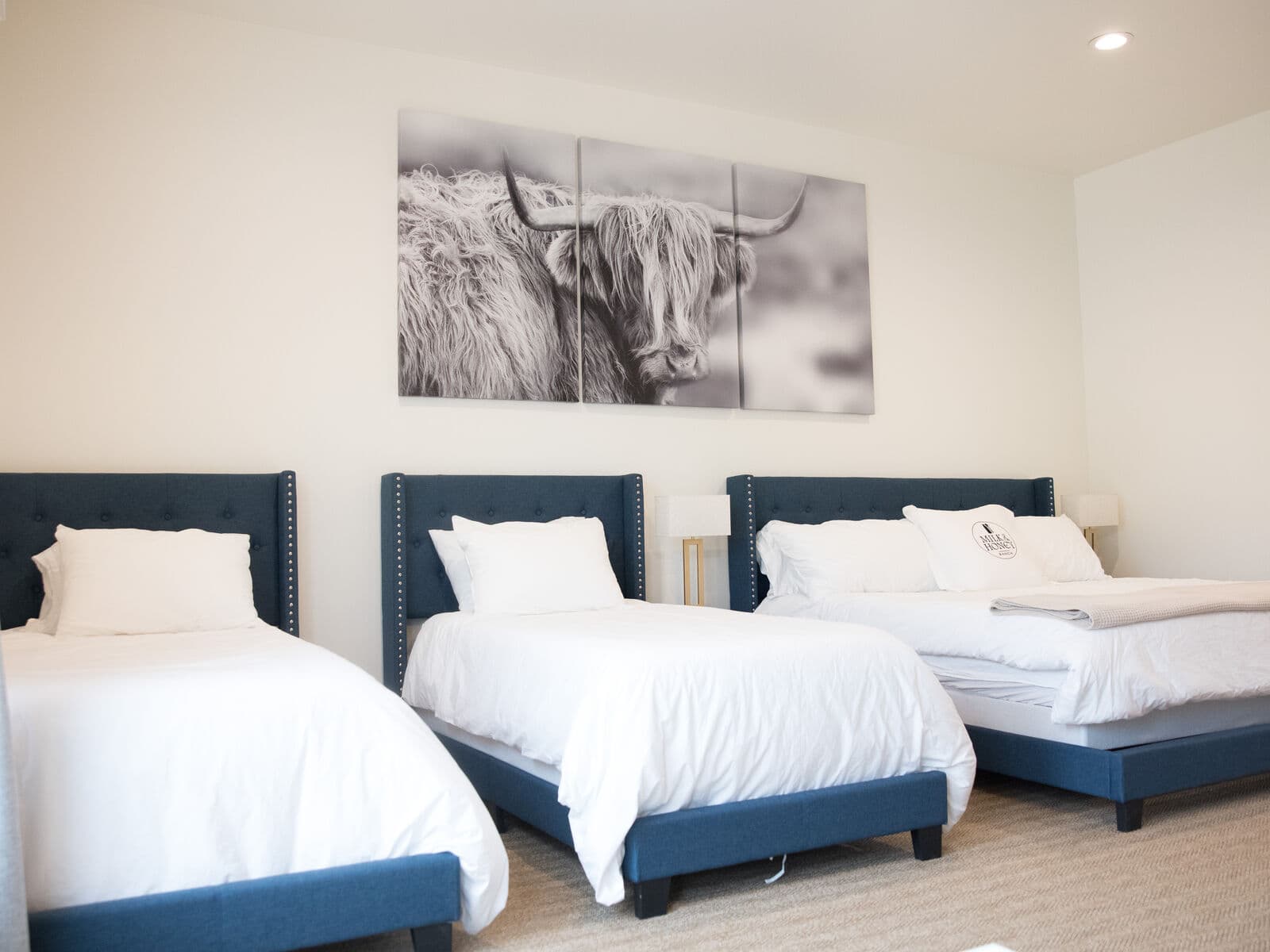 The interior of a luxury ranch stay, with a made bed and warm lamplight